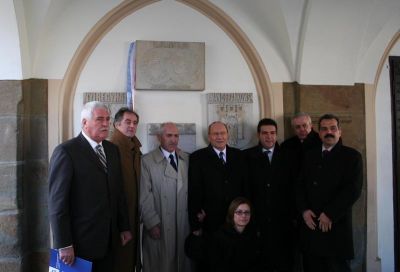 Delegacja grecka stoi przed tablicami miasta partnerskich